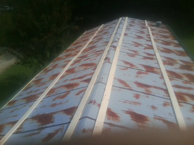 Rusted metal roof panels with new wood purlins before replacement — Storm Damage Roof Repair in Scandia by Roofing Brothers