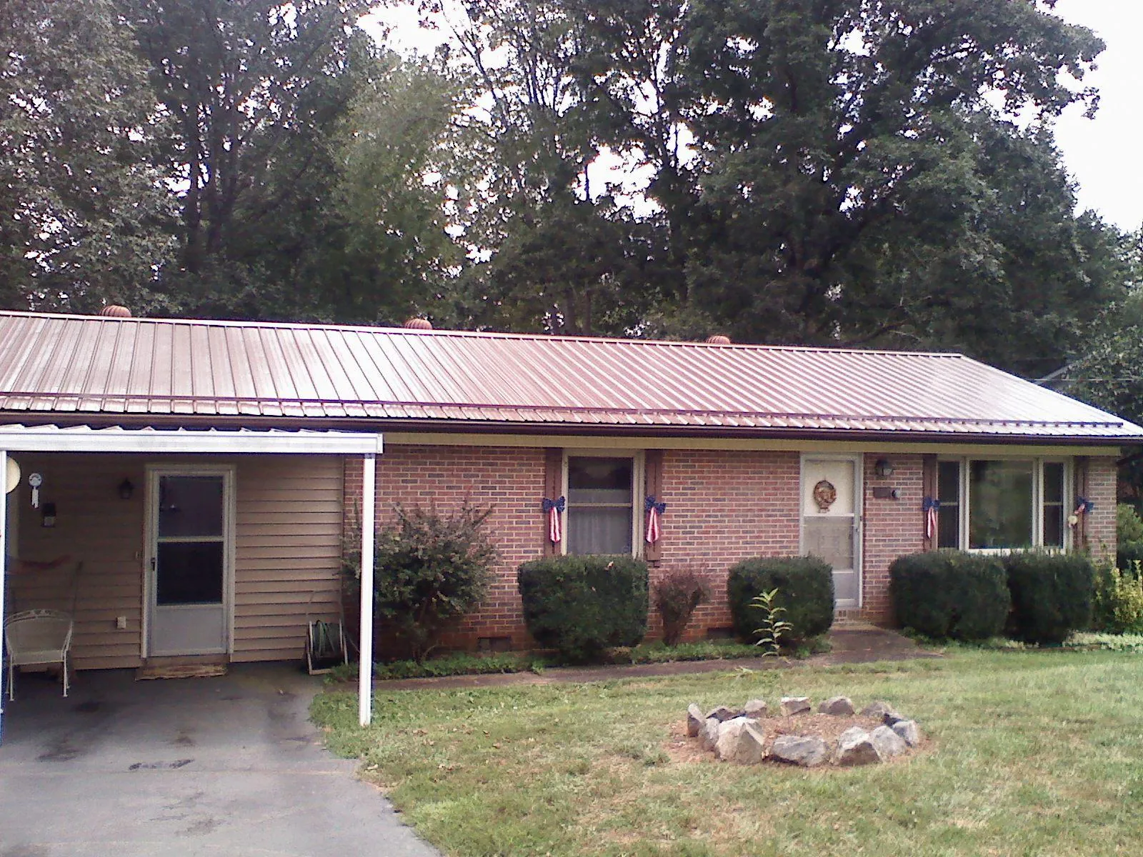 Bronze metal roof and carport on a brick ranch home — Roof Repair work by our crew in Scandia